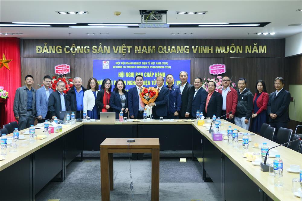 Tiến sĩ Nguyễn Văn Đông, Chủ tịch VEIA (giữa), nhận hoa chúc mừng từ Phó Chủ tịch VCCI, ông Hoàng Quang Phòng, cùng các thanh viên Ban chấp hành VEIA mới được kiện toàn nhân sự.